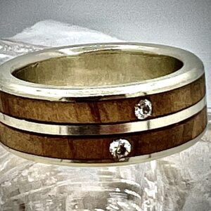 Ring van olijfhout gecombineerd met zilver, ingezet met zitkoontjes